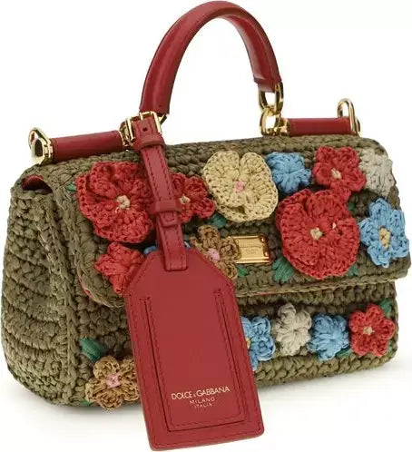Dolce & Gabbana handbag with floral crochet details and red tag on a white background