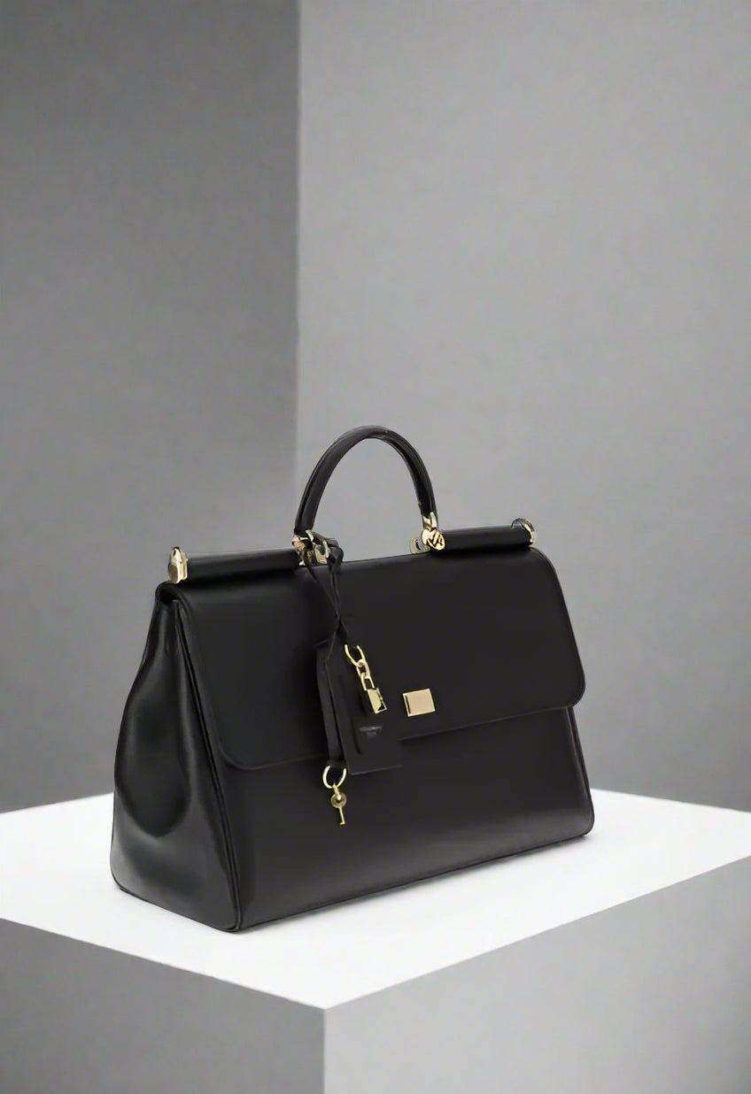 Black handbag with gold accents on a white background