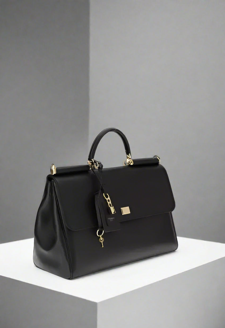 Black handbag with gold accents on a white background