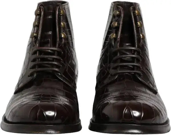 Pair of dark brown leather boots with gold accents on a white background