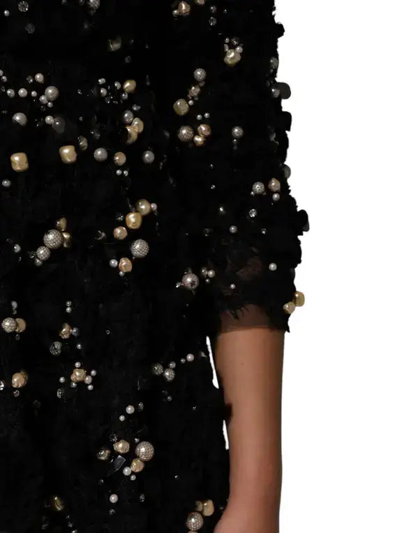 Black dress with pearl embellishments on a white background