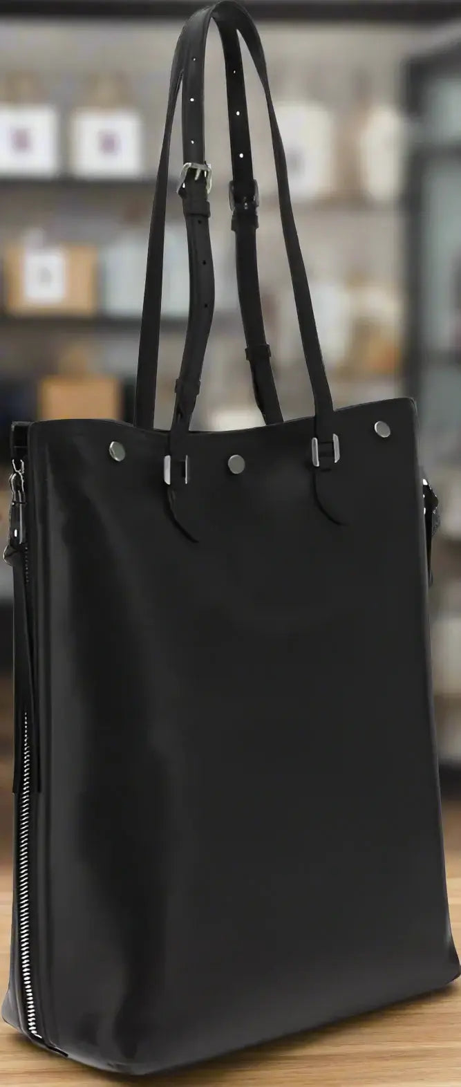 Black tote bag with shoulder straps on a white background
