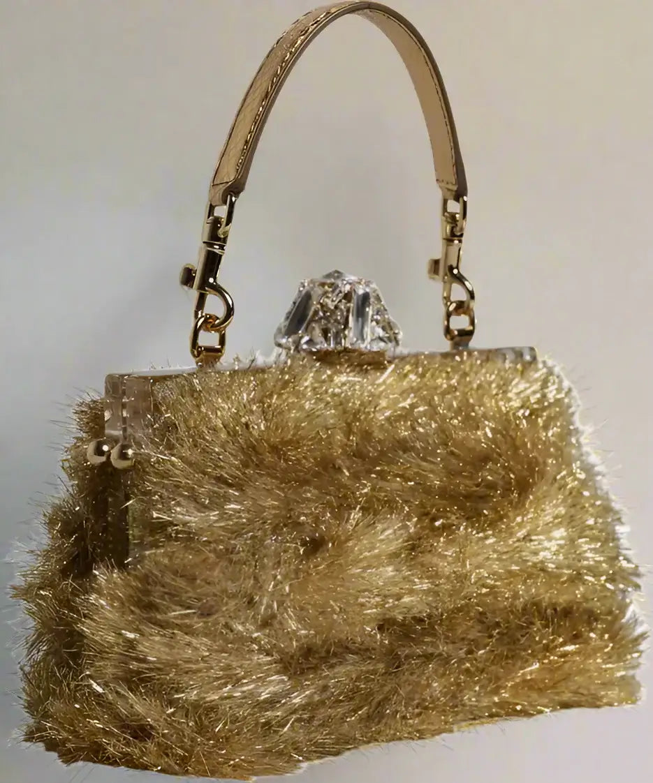 Gold fluffy handbag with a crystal clasp on a white background