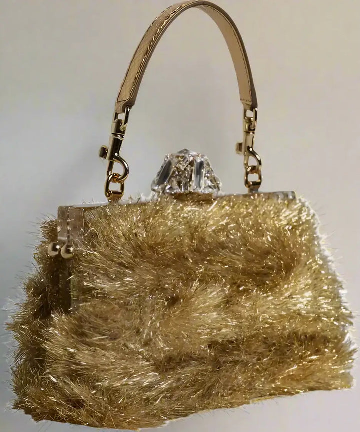Gold fluffy handbag with a crystal clasp on a white background