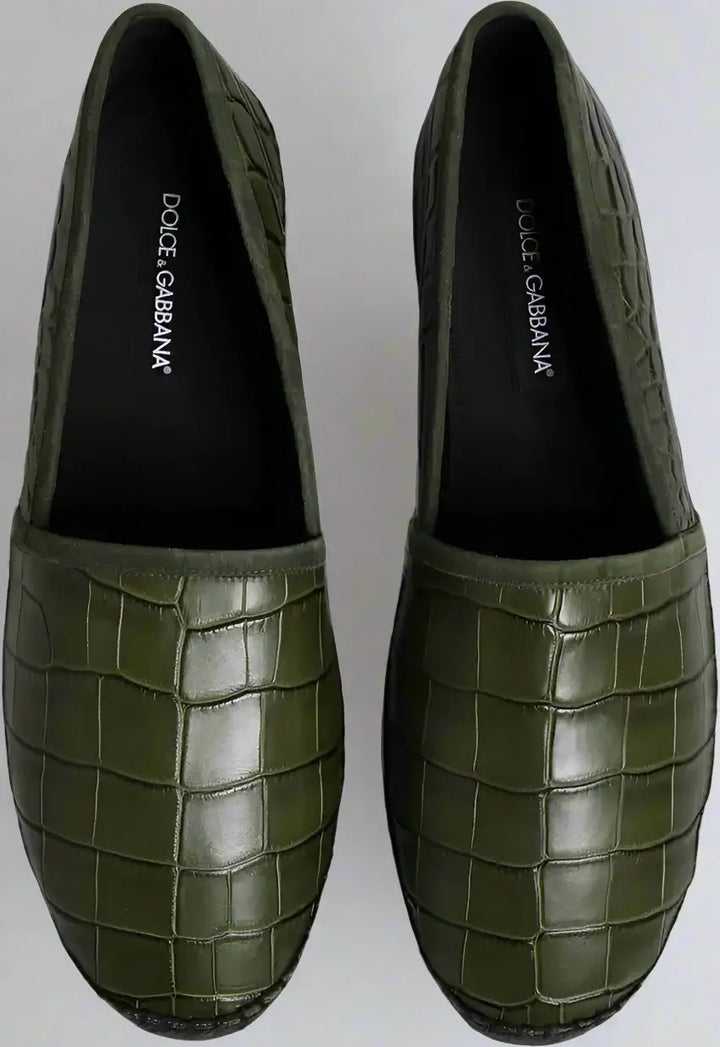 Green loafers with crocodile pattern on a white background