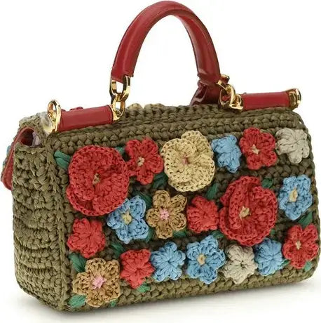 Crocheted handbag with colorful floral patterns on a white background