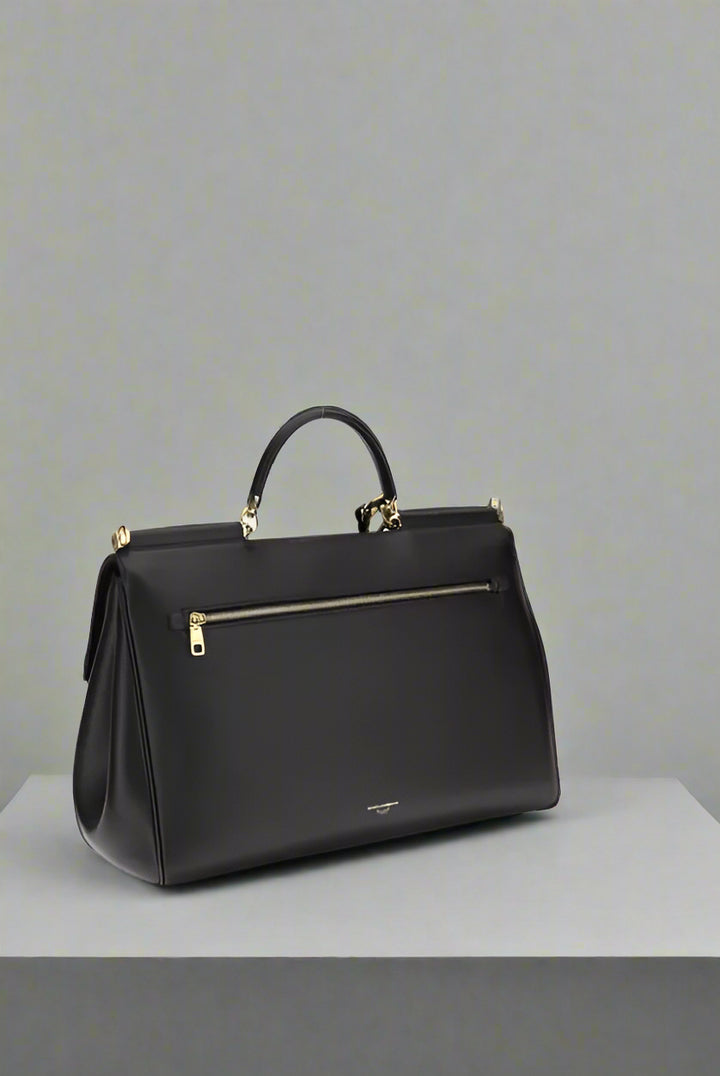Black handbag with gold zipper on a white background
