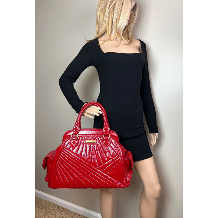 Isabella Fiore Red Patent Leather Hand bag showcased with a model in a black dress, highlighting luxury bags.