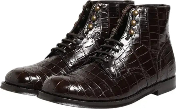 Pair of brown crocodile-patterned boots with gold buttons on a white background