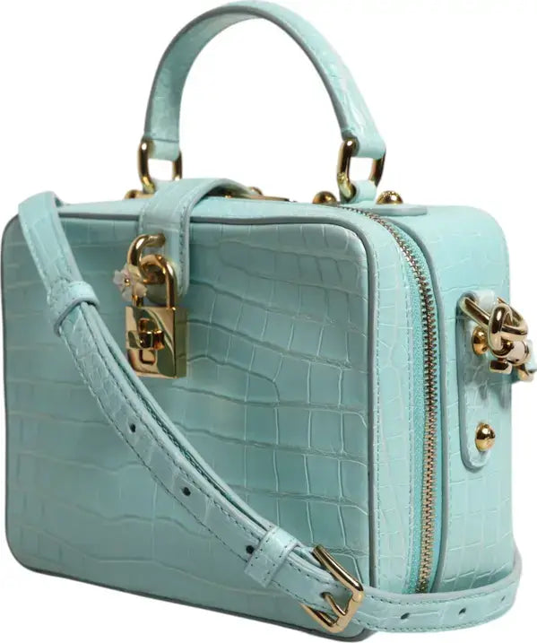 Light blue handbag with gold accents on a white background