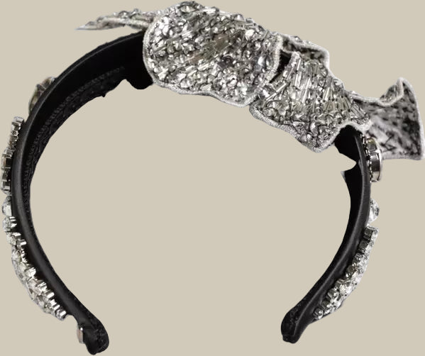 Decorative headband with a large bow made of crystals on a white background