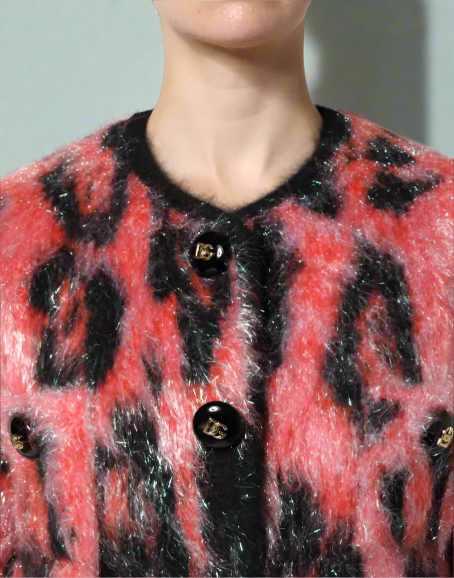 Close-up of a red and black patterned cardigan with buttons on a white background