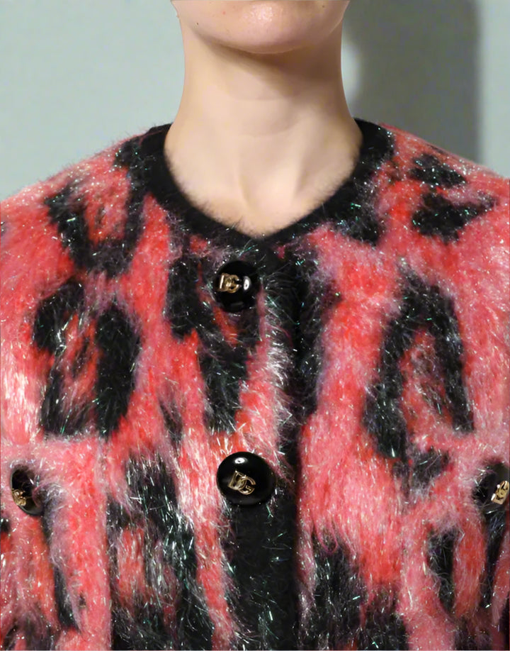 Close-up of a red and black patterned cardigan with buttons on a white background