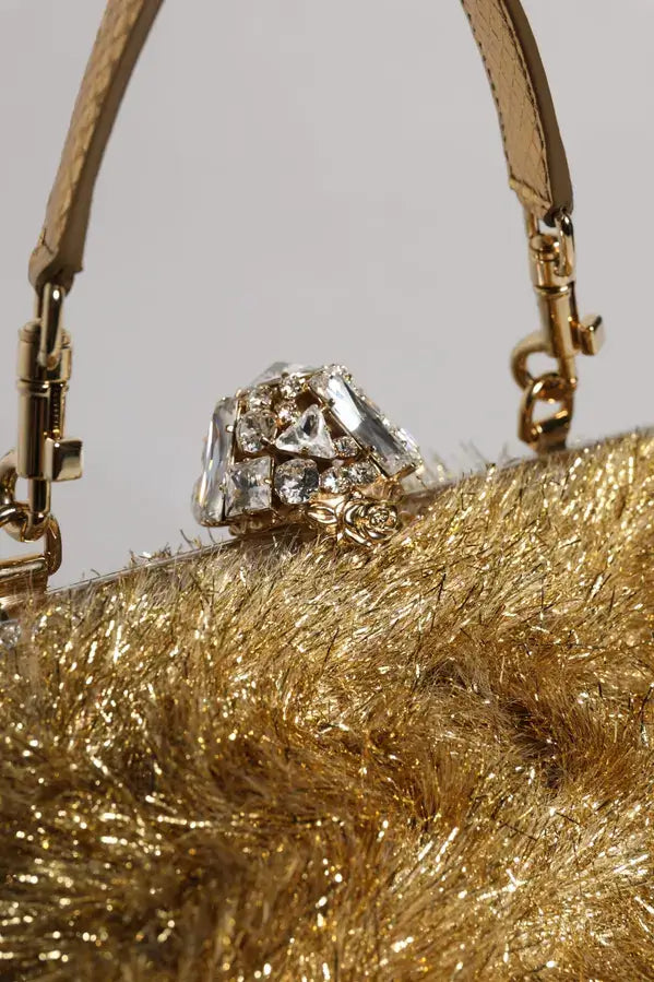 Gold handbag with a textured surface and a decorative element on a light gray background