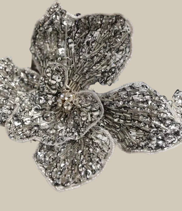 Silver floral headband with intricate design on a white background