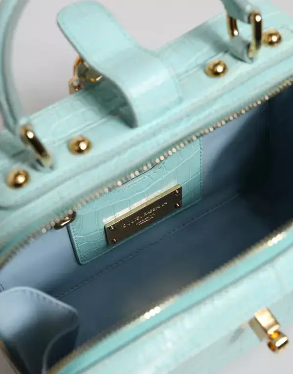 Light blue handbag with gold accents and a visible brand label.