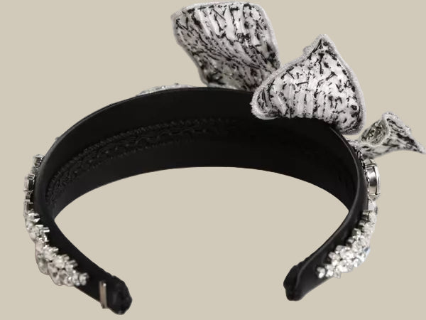 Black headband with silver decorative elements on a white background