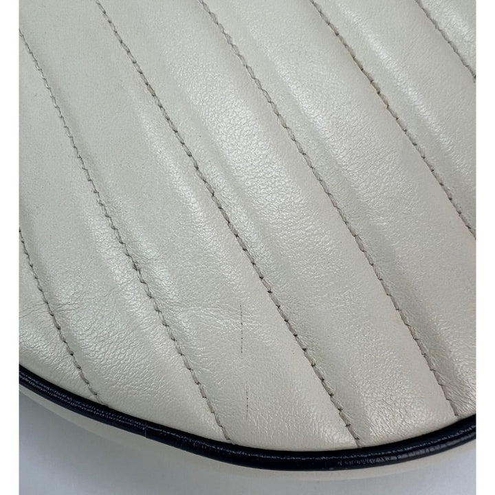 Close-up of a quilted leather saddle pad with visible stitching on a white background