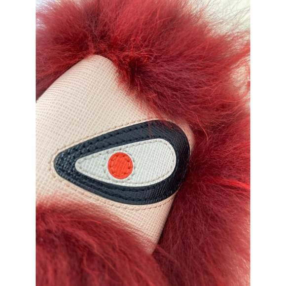 Close-up of a red furry item with a white and black patch featuring a red circle.