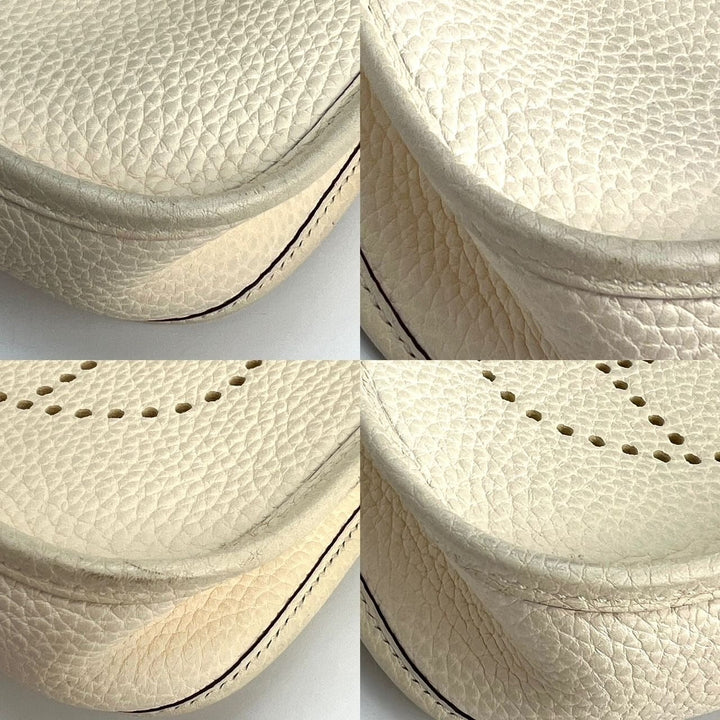 Close-up of a textured beige leather product with stitching details on a white background