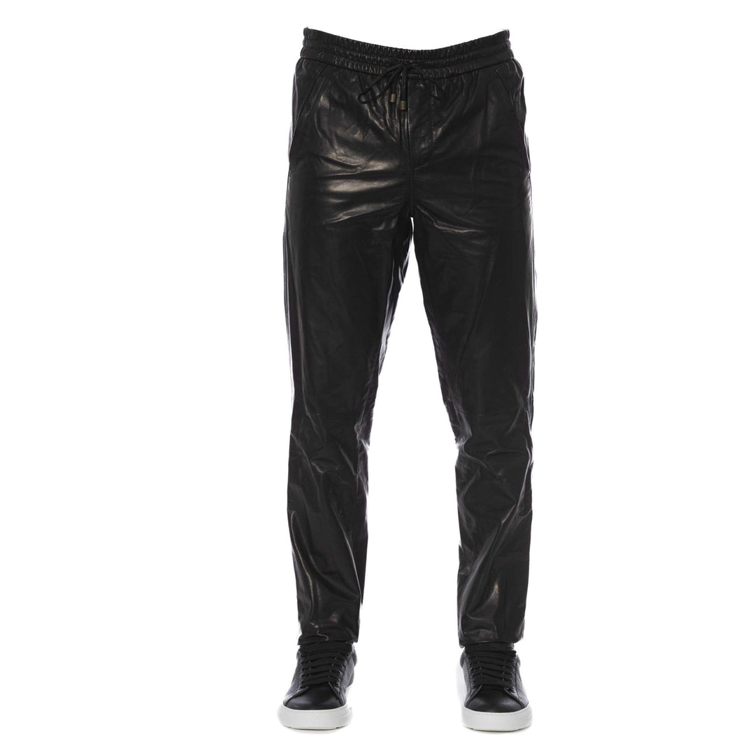 A pair of black Trussardi trousers with a visible logo, designed with two pockets, and a man standing in front wearing white sneakers.