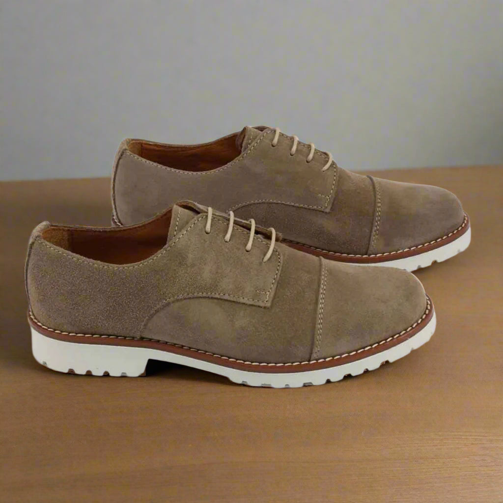 Pair of brown suede shoes on a white background