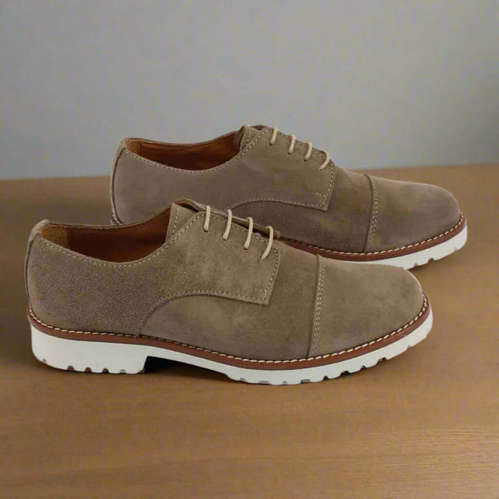 Pair of brown suede shoes on a white background