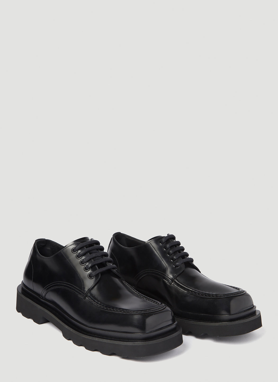 Pair of black leather shoes on a light gray background