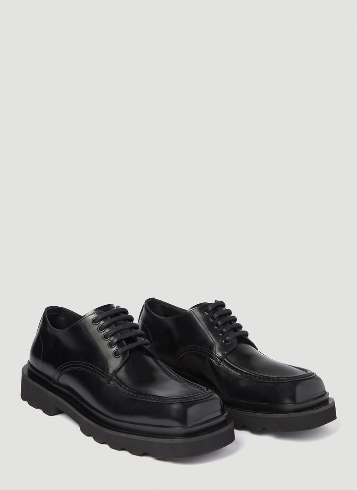 Pair of black leather shoes on a light gray background