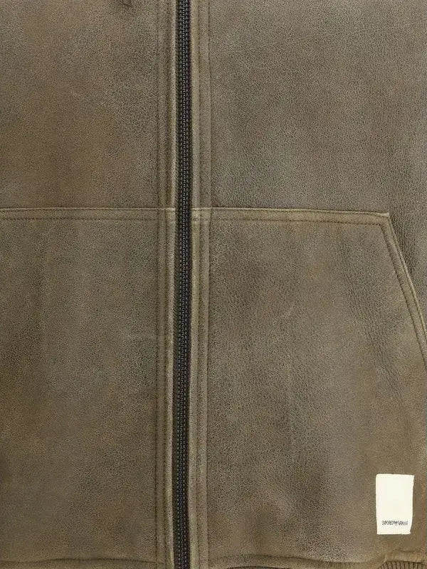 Close-up of a brown suede jacket with a zipper and a visible brand label.