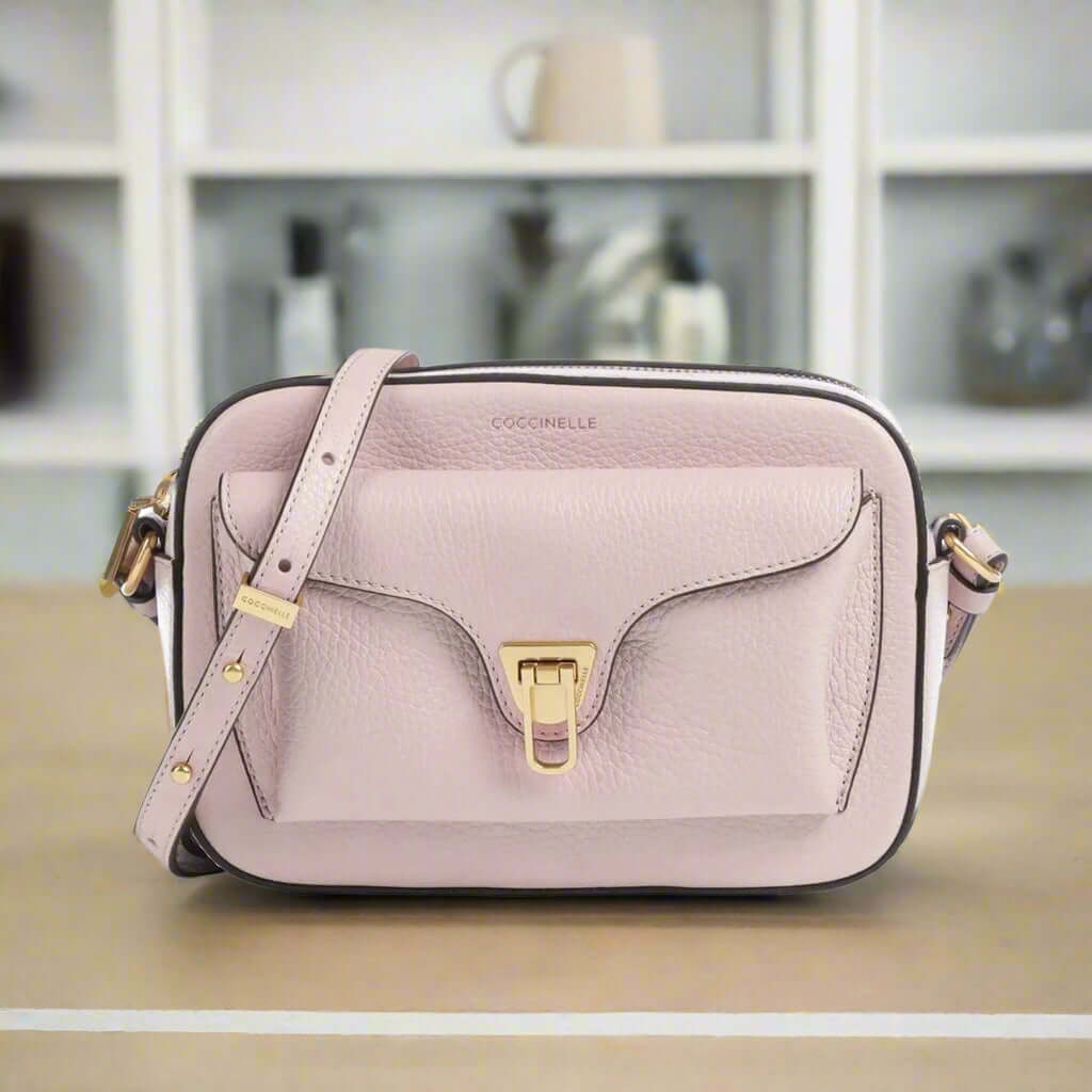 Pink handbag with gold accents on a white background