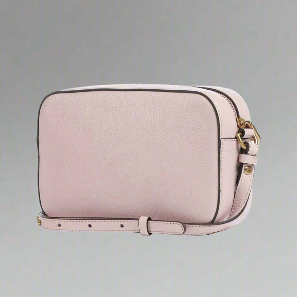 Pink crossbody bag with gold accents on a white background