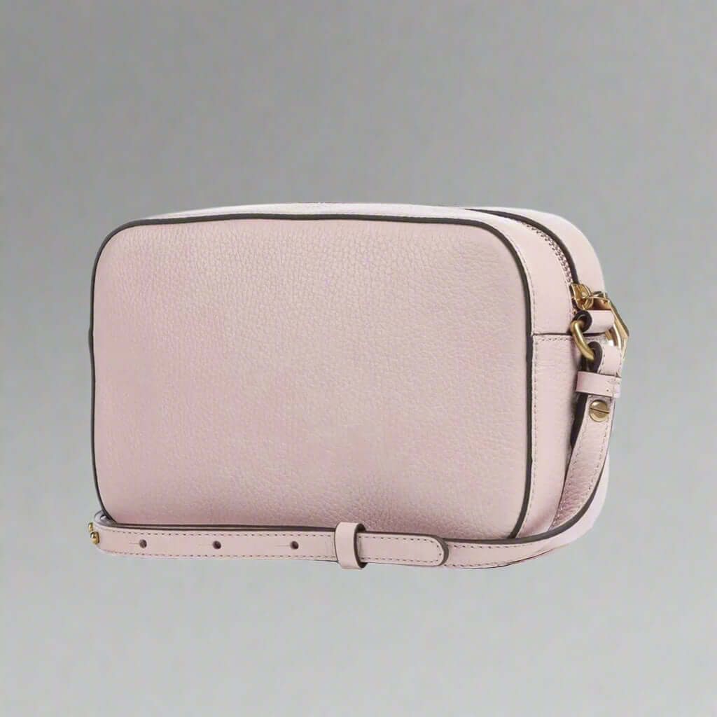 Pink crossbody bag with gold accents on a white background
