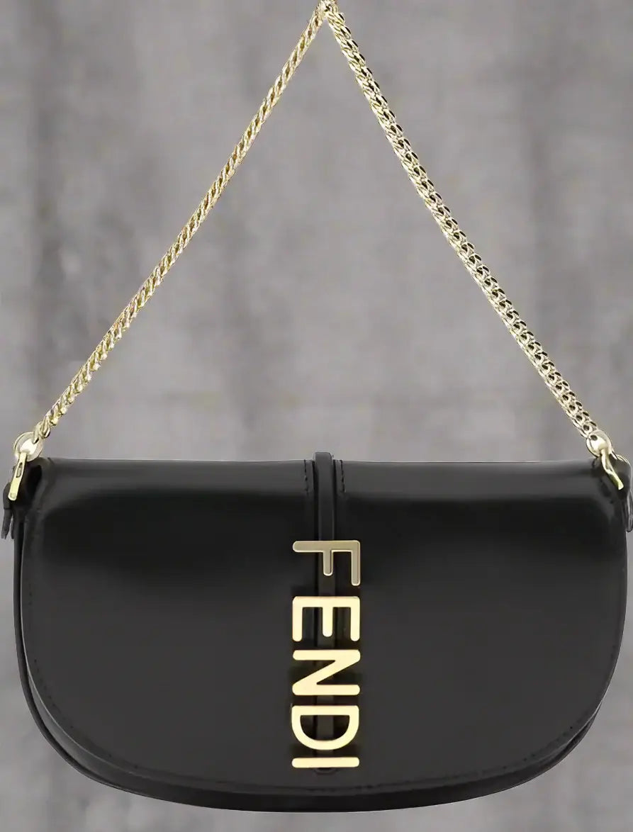 Black handbag with gold chain strap and Fendi logo on a white background