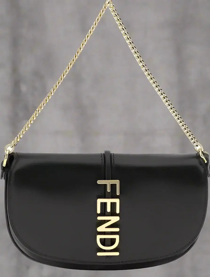 Black handbag with gold chain strap and Fendi logo on a white background