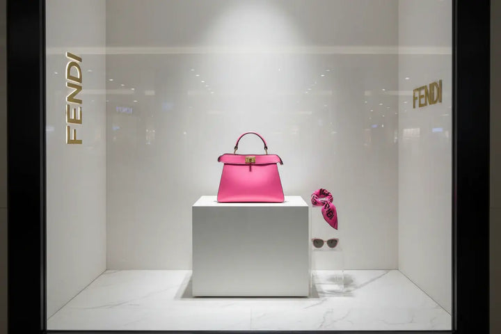 Pink handbag with a gold clasp on a white background
