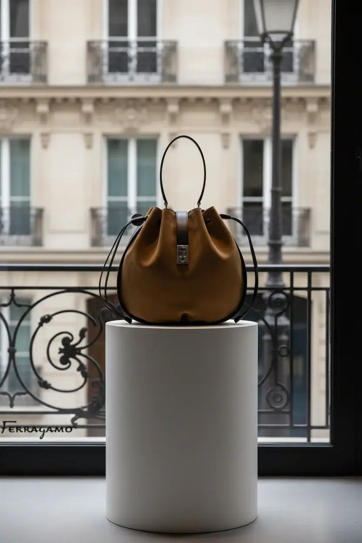 Tan handbag with black accents on a white background
