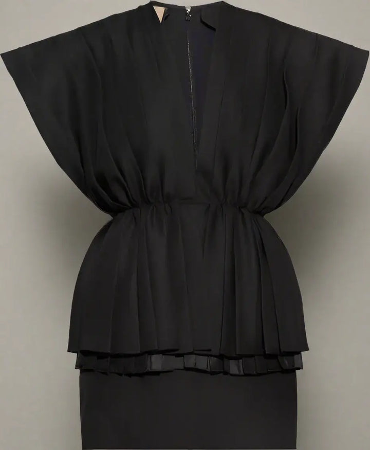 Black peplum top on a white background