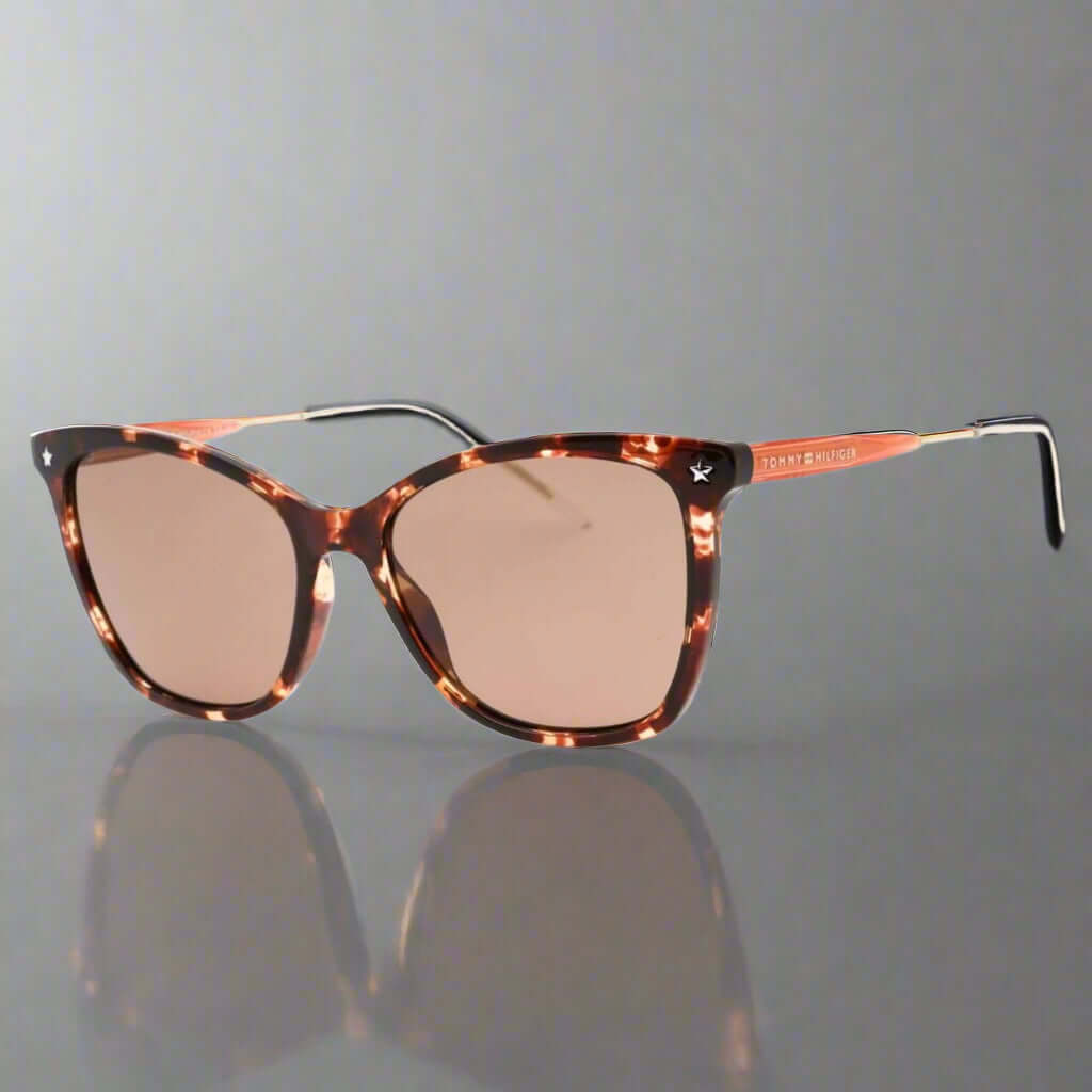 Sunglasses with tortoiseshell frame and brown lenses on a white background