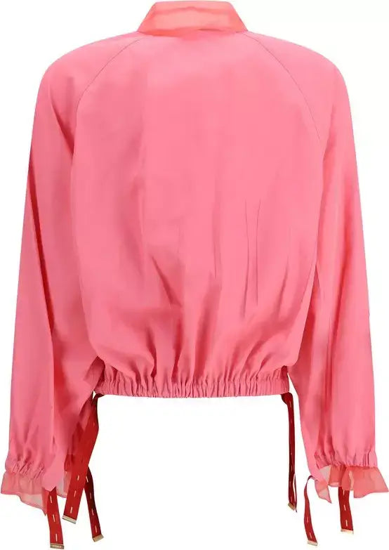 Pink blouse with long sleeves and red accents on a white background