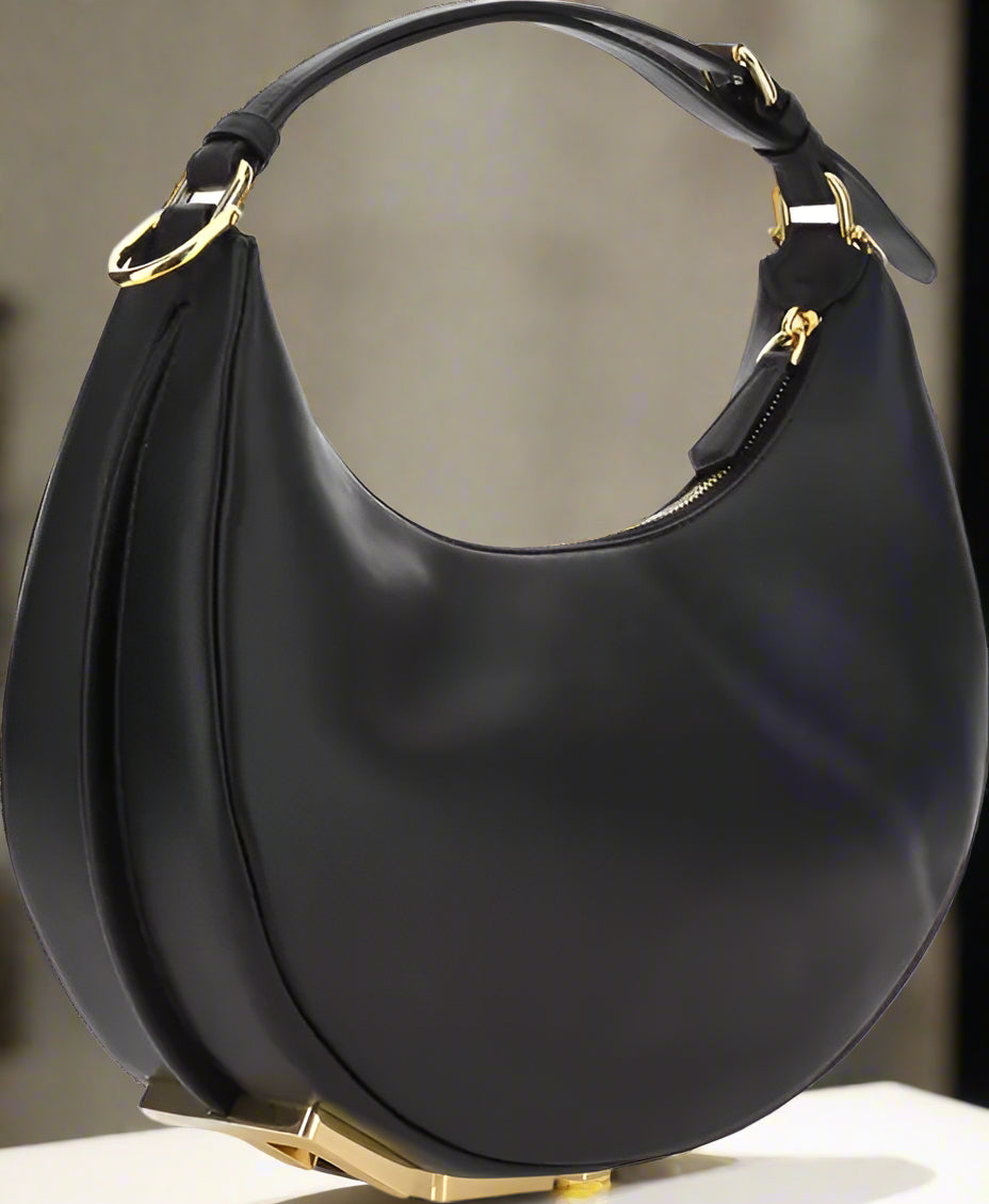 Black handbag with gold accents on a white background
