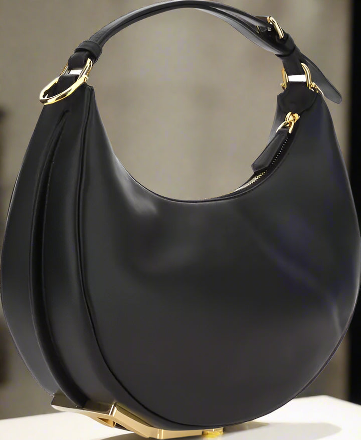 Black handbag with gold accents on a white background