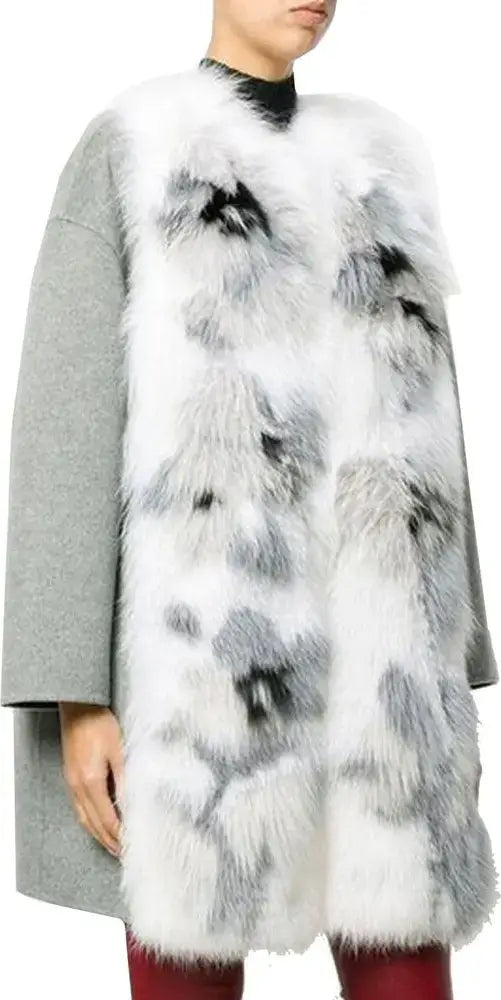 Person wearing a white fur vest with black patterns over a gray coat on a white background