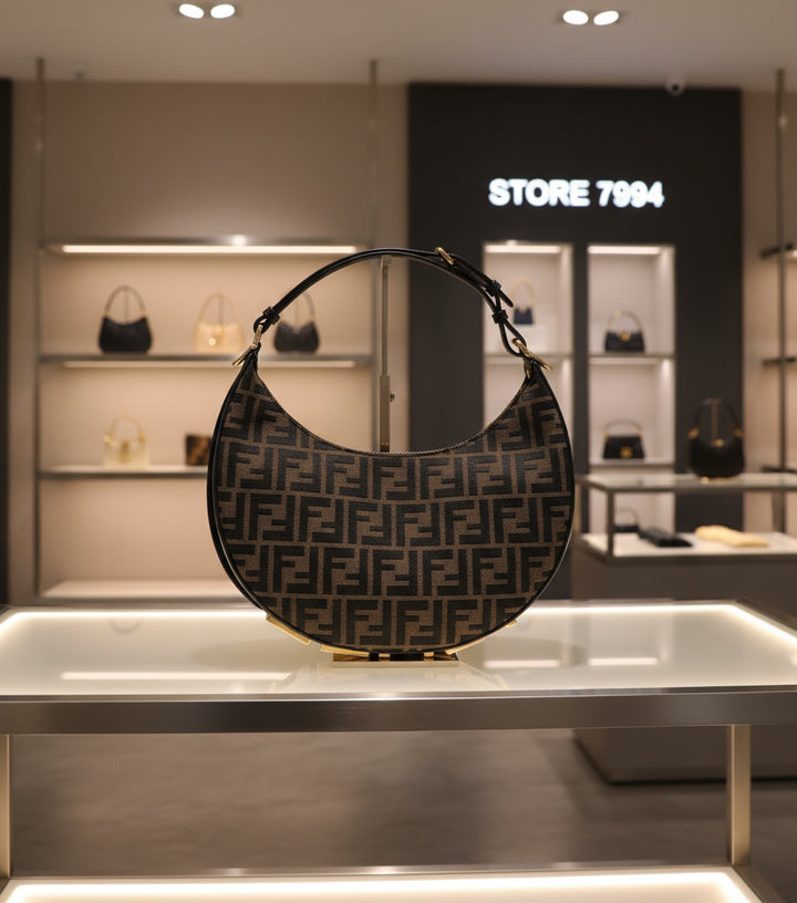 Designer handbag with a prominent logo pattern on a white background