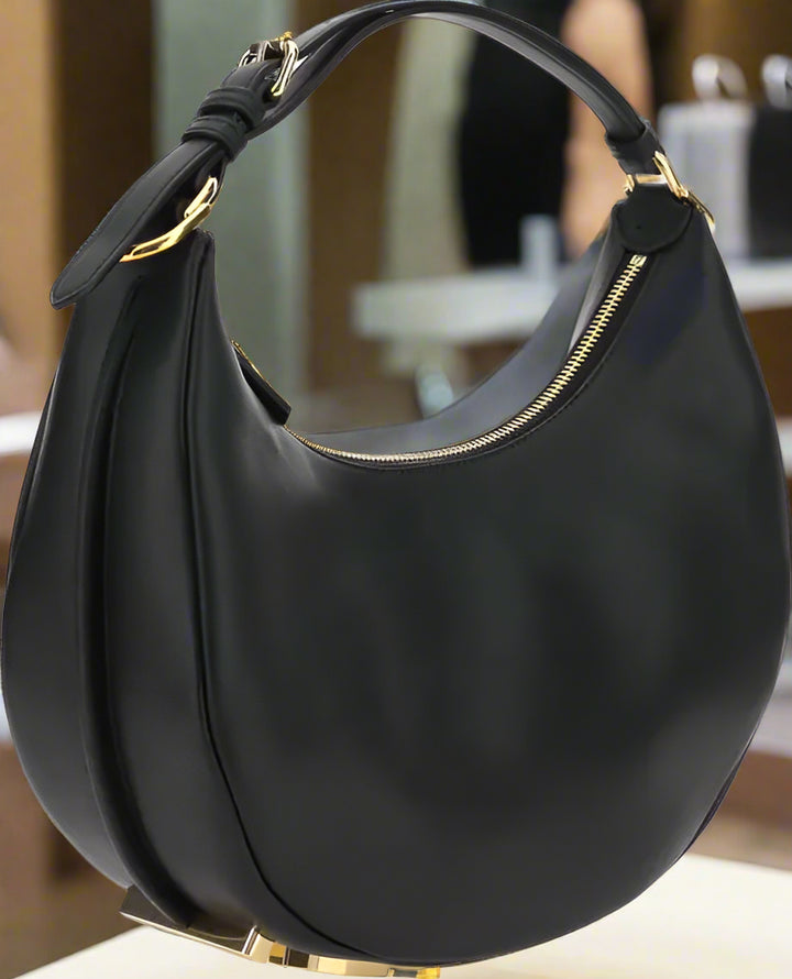 Black handbag with gold accents on a white background