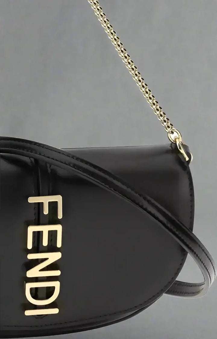 Black Fendi handbag with gold chain strap on a white background