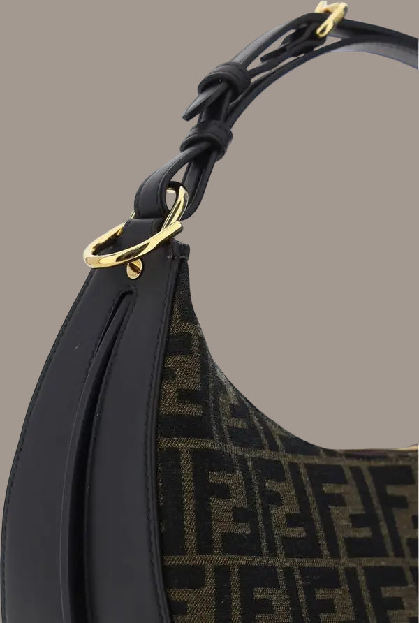 Black handbag with gold hardware on a white background