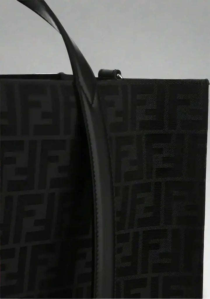Black textured bag with a prominent logo pattern on a white background