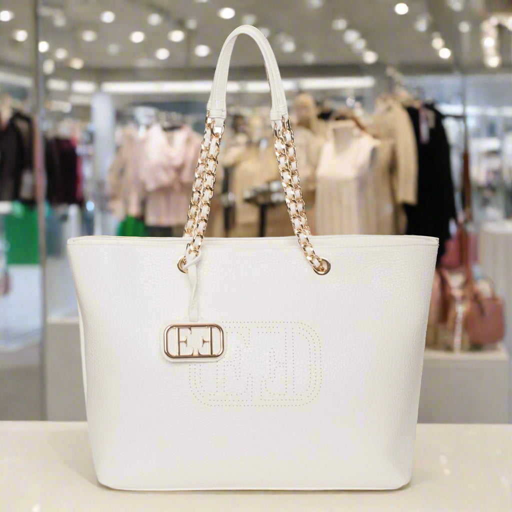 White handbag with gold chain handle and clasp on a white background