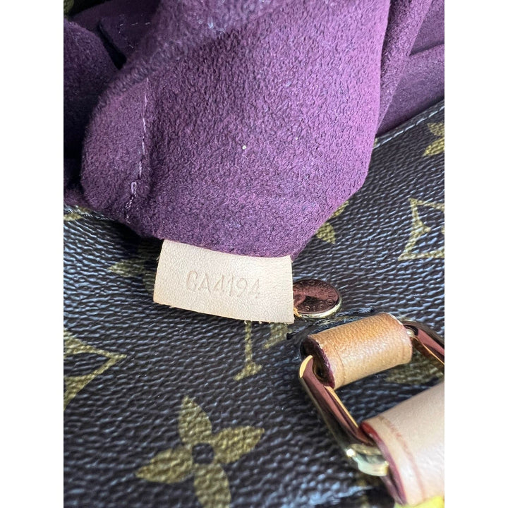 Close-up of a purple fabric item with a brand tag on a textured surface